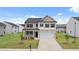 Two-story house with brick and beige siding, white shutters, and a two-car garage at 205 Amberjack Trail, Covington, GA 30016