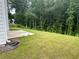 A grassy backyard with a wooded area in the back, perfect for enjoying nature at 2180 Highridge Point Dr, Lithia Springs, GA 30122