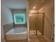 Bright bathroom features a soaking tub, separate shower with tiled enclosure, and window at 2180 Highridge Point Dr, Lithia Springs, GA 30122