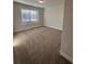 Sunlit bedroom featuring neutral carpet, a window with blinds, and minimal furnishings at 2180 Highridge Point Dr, Lithia Springs, GA 30122