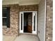Inviting front entry with brick facade and decorative wood door with glass panels, flooding the foyer with natural light at 2180 Highridge Point Dr, Lithia Springs, GA 30122