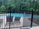 Community pool area surrounded by a black fence, offering a refreshing escape at 2180 Highridge Point Dr, Lithia Springs, GA 30122
