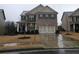 Two-story brick home with a three-car garage and landscaped yard at 2368 Misty Ivy Ct, Buford, GA 30519