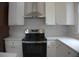Close-up of modern kitchen appliances, including stainless steel range and hood, with white cabinetry at 1089 Avon Sw Ave, Atlanta, GA 30310