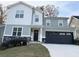 Two-story house with gray and white siding, a black garage door, and landscaping at 2708 Eagles Crest Ln, Decatur, GA 30034