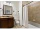 Well-lit bathroom showcasing a granite vanity, toilet, and a shower with neutral tile and a curtain at 3261 Ferncliff Ln, Atlanta, GA 30324