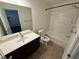 Well-lit bathroom featuring a combination tub and shower unit and vanity with a dark wood cabinet at 2912 Ashlyn Pointe Dr, Atlanta, GA 30340