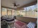 Relaxing screened porch with ceiling fan, wicker furniture, and red rug at 752 Bostonian Way, Lawrenceville, GA 30046