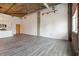 Open living space featuring hardwood floors and exposed brick wall with large window at 3235 Roswell Ne Rd # 716, Atlanta, GA 30305