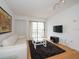 Living room features hardwood floors, white couch, and balcony access at 199 14Th Ne St # 1209, Atlanta, GA 30309