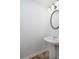 Small powder room featuring a pedestal sink, round mirror, and neutral color palette at 5665 Terremont Cir, Norcross, GA 30093