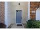 Front entry door with sidelight flanked by brick and stone, and low evergreens at 5665 Terremont Cir, Norcross, GA 30093