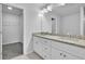 Bathroom featuring double sink vanity with granite countertop, white cabinets, and large mirror at 4101 Fulson Dr, Lilburn, GA 30047