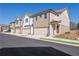 Row of townhomes featuring tan brick and light beige vinyl siding, each with a 2-car garage at 4101 Fulson Dr, Lilburn, GA 30047