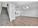 Open living room with stairs and modern lighting flowing into the adjacent kitchen at 4101 Fulson Dr, Lilburn, GA 30047