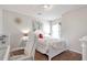 Cozy bedroom featuring white furniture, decorative wall accents, and a sunny window at 661 Towering Pine Se Trl, Lawrenceville, GA 30045