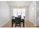 Cozy dining area featuring a dark wood table, black chairs, a chandelier, and a well-lit window at 661 Towering Pine Se Trl, Lawrenceville, GA 30045