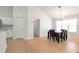 Bright dining area with a modern table set, light-colored tile flooring, and access to the kitchen at 661 Towering Pine Se Trl, Lawrenceville, GA 30045