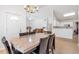 Open concept dining area with a modern table, access to kitchen, and natural light from large windows at 661 Towering Pine Se Trl, Lawrenceville, GA 30045