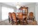 Spacious dining room featuring a wooden table, ornate chairs, a decorative china cabinet, and soft natural lighting at 661 Towering Pine Se Trl, Lawrenceville, GA 30045