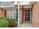 Close-up of a brick home's entrance, showcasing a classic black front door and neat landscaping at 661 Towering Pine Se Trl, Lawrenceville, GA 30045