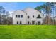 Stunning modern farmhouse exterior boasts a spacious lawn and pristine landscaping at 130 Wesley Pl, Fayetteville, GA 30214