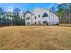 Contemporary farmhouse exterior with expansive lawn and wooded backdrop at 130 Wesley Place, Fayetteville, GA 30214