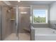 Modern bathroom with a large shower, soaking tub and a window with blinds at 1553 Brunswick St, Lithia Springs, GA 30122