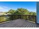 View from the deck showcasing the wood flooring, dark railings, and lush backyard trees at 1553 Brunswick St, Lithia Springs, GA 30122