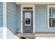 Inviting front entrance with a stylish gray door and well-maintained landscaping at 1553 Brunswick St, Lithia Springs, GA 30122