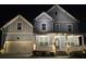 Exterior of the home showcasing the two-car garage, porch, and landscaped front yard at night at 1553 Brunswick St, Lithia Springs, GA 30122