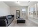 Cozy living room with a large sofa, ottoman, and window with shutters for natural light at 1553 Brunswick St, Lithia Springs, GA 30122