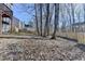 A fenced backyard features a wooded perimeter and a hillside covered with leaves at 355 Holland Springs Way, Powder Springs, GA 30127