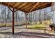 View of a brick patio with a wood roof and wooden support columns overlooking a fenced backyard at 355 Holland Springs Way, Powder Springs, GA 30127