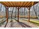 View of a brick patio with a wood roof and wooden support columns overlooking a fenced backyard at 355 Holland Springs Way, Powder Springs, GA 30127