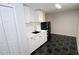 Small basement kitchenette with white cabinets and black appliances at 355 Holland Springs Way, Powder Springs, GA 30127