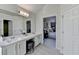 Bright bathroom featuring a large mirror and an open doorway to the main bedroom at 355 Holland Springs Way, Powder Springs, GA 30127