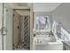 Bathroom with a tiled glass shower, soaking tub, a window, and a towel rack at 355 Holland Springs Way, Powder Springs, GA 30127