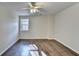 A naturally illuminated bedroom with wood-look floors has a window overlooking the trees at 355 Holland Springs Way, Powder Springs, GA 30127