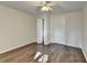 Bedroom with wood-look floors has a ceiling fan and doors to an ensuite and closet at 355 Holland Springs Way, Powder Springs, GA 30127