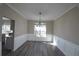 Elegant dining room with chandelier, wainscoting, and hardwood floors at 355 Holland Springs Way, Powder Springs, GA 30127