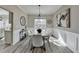 Bright dining room features modern light fixture, gray walls, and white wainscoting at 355 Holland Springs Way, Powder Springs, GA 30127