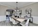 Well-lit dining room with wood table, arched doorway, and modern light fixture at 355 Holland Springs Way, Powder Springs, GA 30127