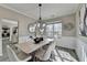 Bright dining room with modern light fixture, wainscoting, and gray wood-look floors at 355 Holland Springs Way, Powder Springs, GA 30127