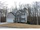 Two-story house with gray siding, stone accents, and a white garage door at 355 Holland Springs Way, Powder Springs, GA 30127