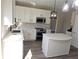 White kitchen with stainless steel appliances and a large quartz island at 355 Holland Springs Way, Powder Springs, GA 30127