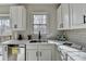 Bright kitchen with stainless steel dishwasher, quartz countertops, and white cabinets at 355 Holland Springs Way, Powder Springs, GA 30127