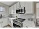 Bright kitchen with stainless steel appliances, white cabinets, and quartz countertops at 355 Holland Springs Way, Powder Springs, GA 30127