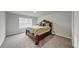 Spacious bedroom with neutral carpet and walls, features a large window and an ornate wooden bed frame at 8819 Sibella Ct, Lithia Springs, GA 30122