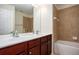 A bathroom featuring a double vanity with cherry cabinets, tile flooring, and a shower tub at 5104 Leeshire Se Trl # 64, Atlanta, GA 30339